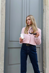 a lady wears a light pink jacket with dark wash jeans